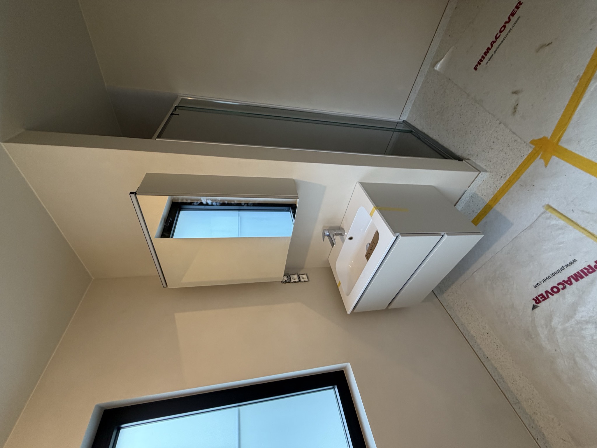 Microcement badkamer met douche en naadloze wandafwerking