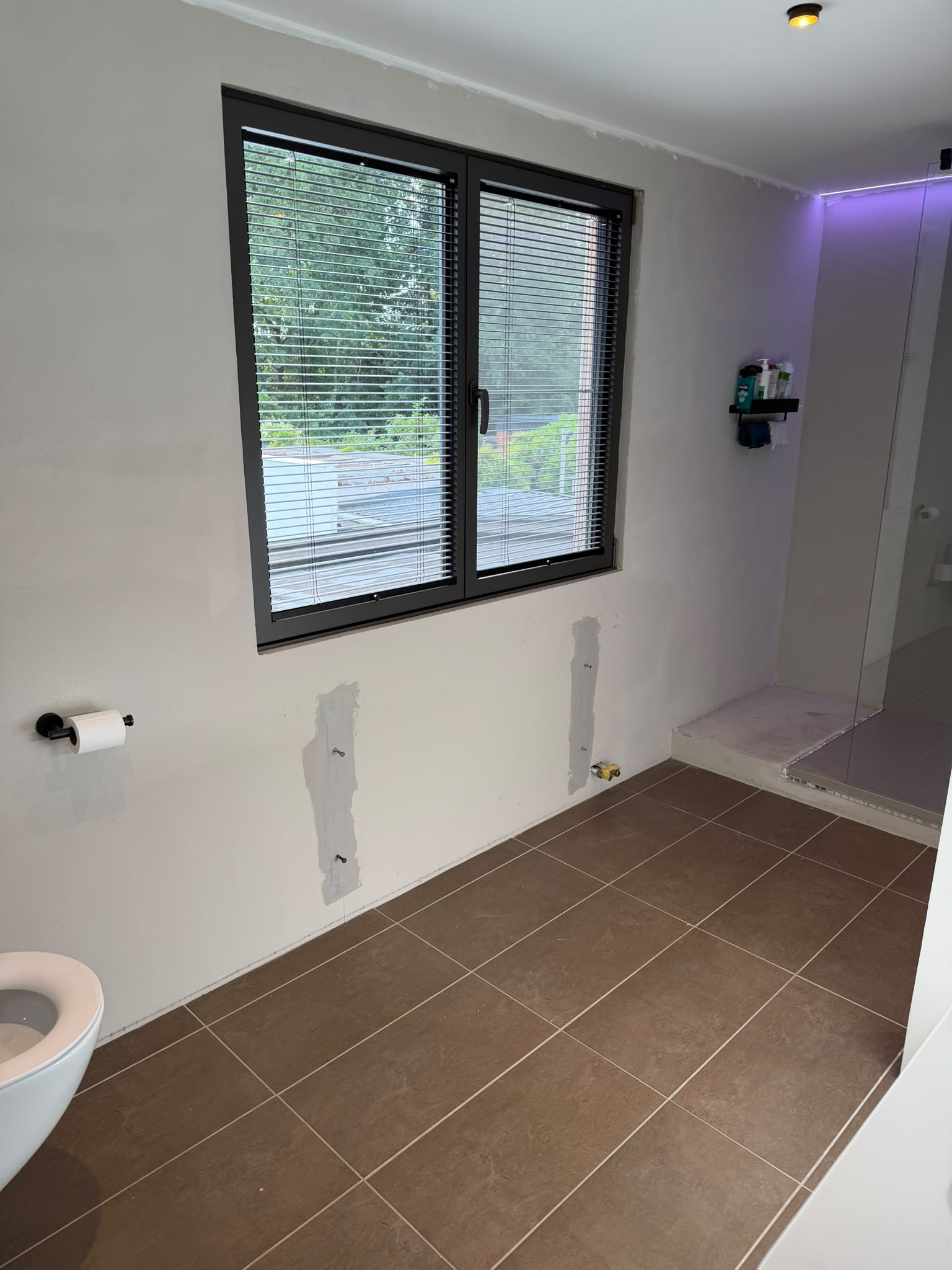 Badkamer voor de werken - betegelde vloer en geschilderde wanden