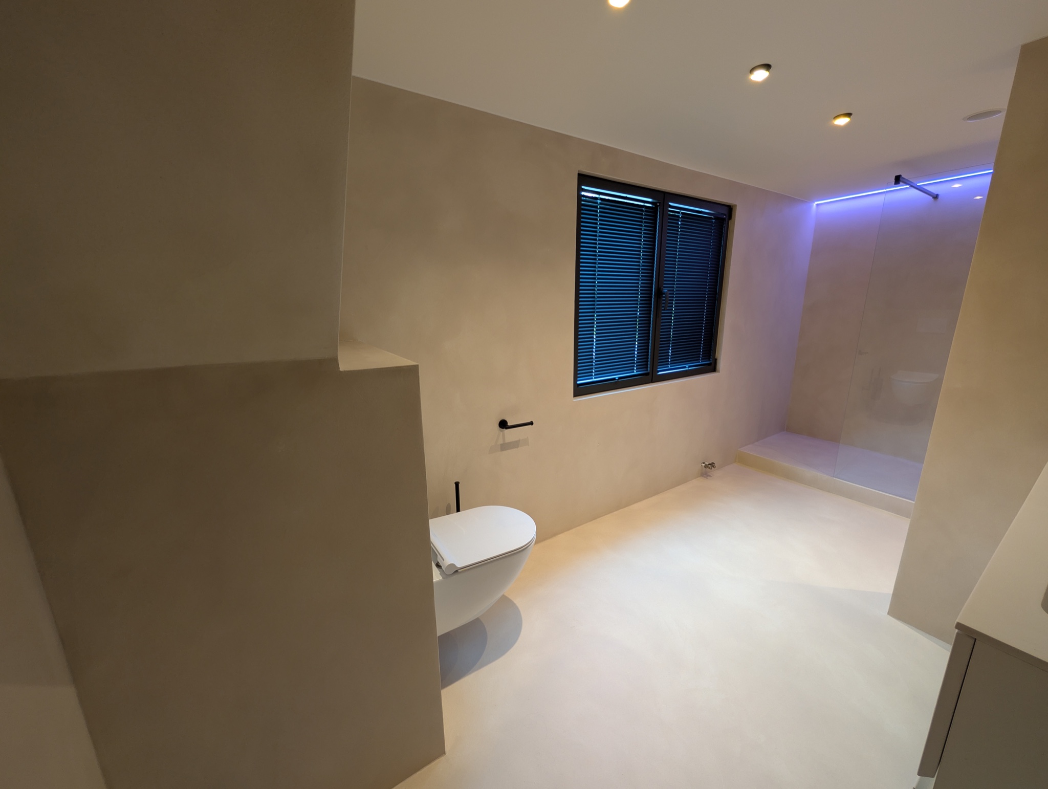 Microcement badkamer met zwevend toilet en inloopdouche