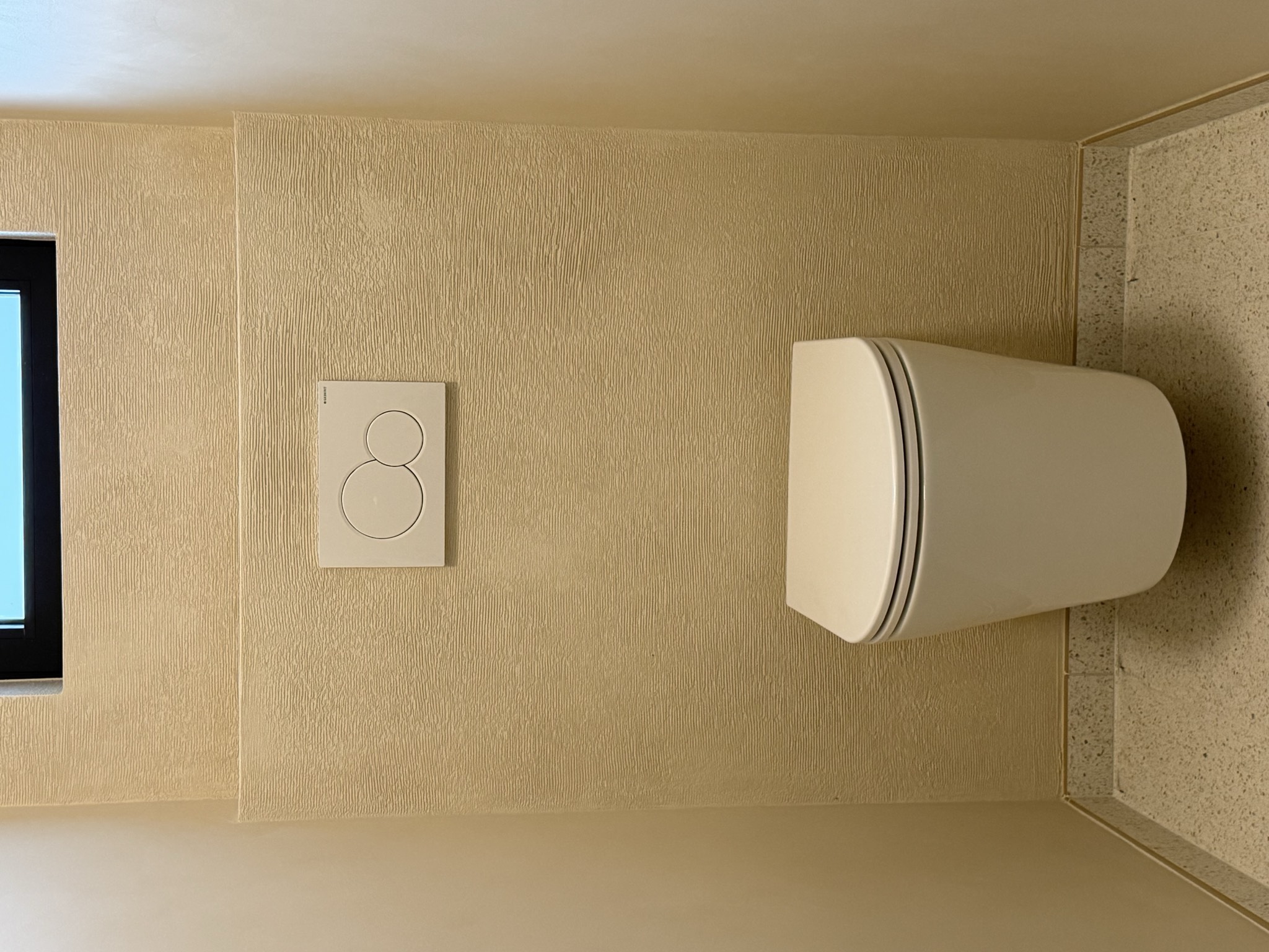 Microcement toilet met gestructureerde wandafwerking