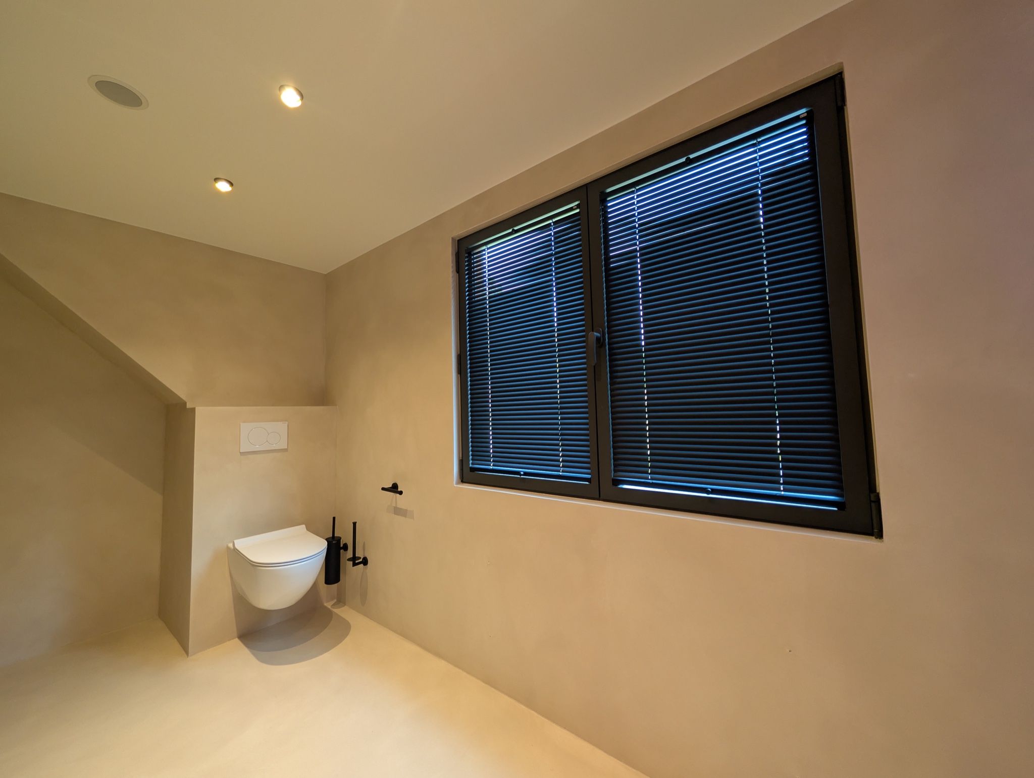 Microcement toilet met naadloze vloer en wandafwerking